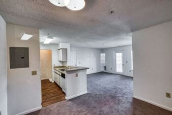 an empty kitchen and living room with white walls